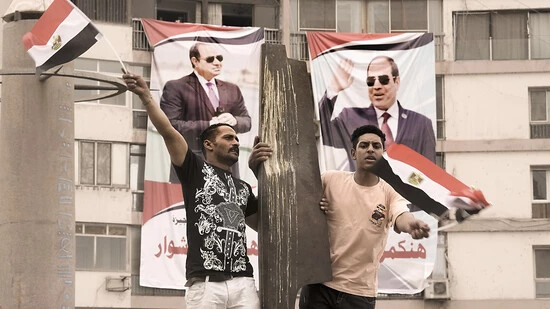 Zwei Anhänger des ägyptischen Präsidenten al-Sisi schwenken ägyptische Nationalfahnen. Foto: Amr Nabil/AP/dpa