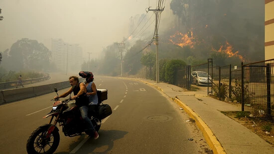 dpatopbilder - Anwohner in Chile bringen sich in Sicherheit, während der Rauch der Waldbrände den Himmel füllt. Foto: Esteban Felix/AP