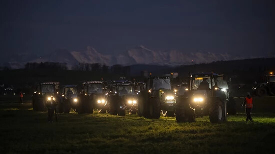 Vertreterinnen und Vertreter der Bauernbewegung fanden sich am Freitagabend mit ihren Traktoren zu einer Mahnwache in Kirchberg BE ein. Im Hintergrund die Berner Alpen mit Eiger, Mönch und Jungfrau.