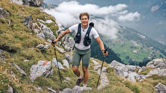 Immer noch zuversichtlich: Tim Basler kann nach 80 Kilometern auf dem Weg zur Furggele mit Tiefblick auf Braunwald noch lachen.
