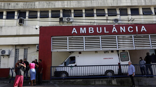 Menschen warten vor dem Getulio-Vargas-Krankenhaus auf die Ankunft der Menschen, die bei einem Polizei-Einsatz in der Favela Vila Cruzeiro verletzt oder getötet wurden. Foto: Bruna Prado/AP/dpa