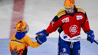 Der Davoser PostFinance Top Scorer Matej Stransky wird von einem  Nachwuchsspieler auf dem Eis begrüsst. Der HC Davos spielte am 4. Februar gegen die SCL Tigers in speziellen Trikots des Sponsors Rhätische Bahn.