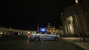 Ein italienisches Polizeiauto fährt am späten Abend vor dem Petersplatz im Vatikan vorbei. Foto: Andrew Medichini/AP/dpa