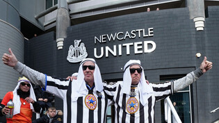 Ambivalent: Nachdem der Saudische Staatsfonds ihren Klub gekauft hat, posieren zwei Newcastle-United-Fans in entsprechender Kleidung vor dem Stadion.  