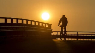 Ein Radfahrer fährt über eine Brücke in Felsberg dem Paradies entgegen.