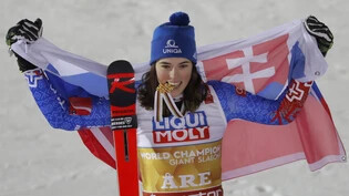 Petra Vlhova, das Gold zwischen den Zähnen, präsentiert sich stolz mit der slowakischen Flagge