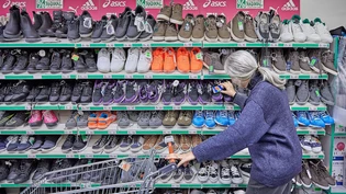 Wer auf Sozialhilfe angewiesen ist, muss jeden Franken zweimal umdrehen: Eine ältere Frau schaut sich bei einem Discounter Schuhe aus Restposten an. 