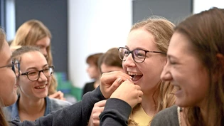 Nicht hinsehen: Jessica Föhn lässt sich das allererste Insektenessen von ihrer Freundin verabreichen.
