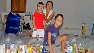 Die Ausgewanderten: Nadja Monson-Stucki und ihre Söhne Fynn (links) und Kye stellen in ihrer Garage die Lebensmittelpakete zusammen, welche in den Townships verteilt werden.