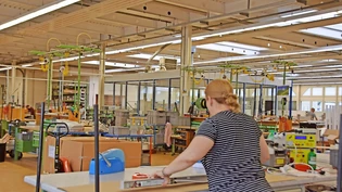 In der grossen Produktionshalle der Tulux sind nicht alle Arbeitsplätze besetzt: Bete Spaqi packt eine Leuchte ein.