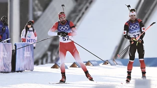 Benjamin Weger läuft in den Schiessstand ein beobachtet die Windfähnchen.