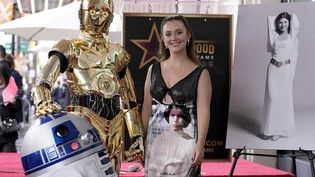 "Star Wars"-Ikone Carrie Fisher hat posthum einen Stern auf dem berühmten "Walk of Fame" in Hollywood erhalten. Fishers Tochter Billie Lourd nahm die Ehrung am Donnerstag an der Seite der "Star Wars"-Roboter C-3PO und R2-D2 in Los Angeles in Empfang.