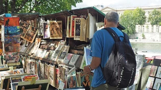ARCHIV - Ein Mann schaut sich an einem der Bücherstände der Bouquinistes de Paris am Seineufer um. Foto: Rachel Boßmeyer/dpa