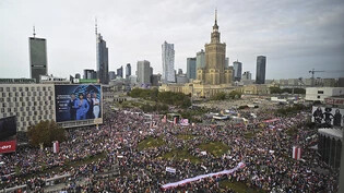 Tausende Menschen versammeln sich in Warschau zum «Marsch der Million Herzen». Der polnische Oppositionsführer Donald Tusk führt die Kundgebung an. Foto: Rafal Oleksiewicz/AP/dpa