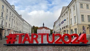 Ein Schriftzug «#Tartu2024» ist in Großbuchstaben auf dem Rathausplatz der estnischen Stadt Tartu aufgestellt. Foto: Alexander Welscher/dpa