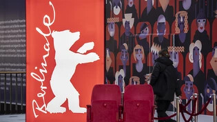 ARCHIV - Eine Frau geht am Logo der Filmfestspiele Berlinale vorbei. Foto: Paul Zinken/dpa