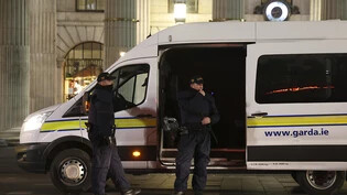 Polizisten stehen in Dublin Wache. Nach einem Messerangriff in der irischen Hauptstadt kam es zu schweren Ausschreitungen. Foto: Peter Morrison/AP/dpa