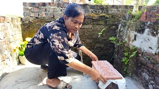 PRODUKTION - Nguyen Thi Nhiem wählt rechteckige Tongefäße aus, in denen sie die Föten in Massengräbern beerdigt. Foto: Bac Pham/dpa