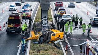 Ein Hubschrauber liegt nach einem Unfall auf der Autobahn M-40 in Madrid. Der Hubschrauber ist aus bisher ungeklärter Ursache am Freitag auf die viel befahrene Ringautobahn M-40 rund um die spanische Hauptstadt Madrid gestürzt. Foto: Matias Chiofalo…