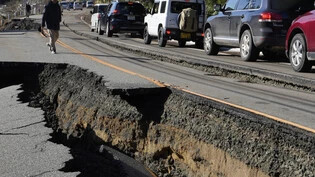 Autos stauen sich auf einer teilweise eingestürzten Straße, nach einem starken Erdbeben in der Nähe der Stadt Anamizu. Die Zahl der Todesopfer infolge einer Serie starker Erdbeben an der Westküste Japans ist weiter gestiegen. Foto: Hiro Komae/AP/dpa
