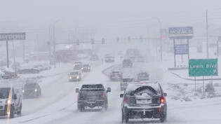 dpatopbilder - Der Verkehr staut sich bei Schneefall auf einer schneebedeckten Straße. Schneestürme im Westen, Tornados im Süden und Regen mit Hochwassergefahr im Osten: Weite Teile der USA werden derzeit von Unwettern heimgesacht, wie US-Medien und…
