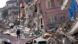 ARCHIV - Ein Mann geht über die Trümmer eingestürzter Gebäude. Am 6. Februar 2023 erschütterten zwei Beben der Stärke 7,7 und 7,6 die Südosttürkei. Foto: Hussein Malla/AP/dpa
