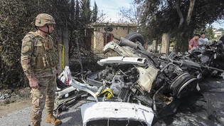ARCHIV - Ein libanesischer Armeeoffizier begutachtet ein zerstörtes Auto. Nach einem mutmaßlich israelischen Drohnenangriff auf ein Auto im Osten des Libanons erlag ein Mann seinen Verletzungen, wie die libanesische Staatsagentur NNA mitteilte. Foto:…