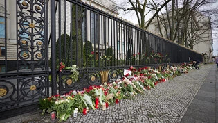 Blumen liegen am Zaun der russischen Botschaft in Berlin. Die Anteilnahme nach dem Terroranschlag auf das Veranstaltungszentrum Crocus City Hall am Stadtrand von Moskau ist groß. Foto: Jörg Carstensen/dpa