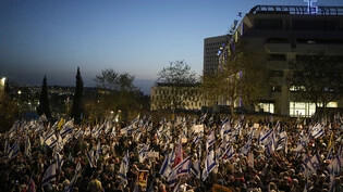 Menschen protestieren gegen die Regierung des israelischen Ministerpräsidenten Netanjahu und fordern die Freilassung der Geiseln, die im Gazastreifen von der Hamas festgehalten werden, vor der Knesset, dem israelischen Parlament. Foto: Leo Correa/AP/dpa