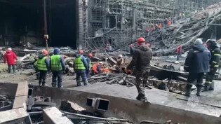 HANDOUT - Auf diesem vom Pressedienst des russischen Katastrophenschutzministeriums veröffentlichten Foto arbeiten Rettungskräfte in der ausgebrannten Konzerthalle nach einem Terroranschlag auf das Gebäude der Crocus City Hall. Foto: Uncredited/Russian…