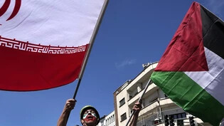 ARCHIV - Ein Mann, dessen Gesicht in den Farben der iranischen Fahne bemalt ist, skandiert Slogans, während er die iranische Fahne bei der jährlichen Kundgebung zum Al-Quds-Tag oder Jerusalem-Tag zur Unterstützung der Palästinenser schwenkt. Foto: Vahid…