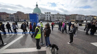 Kontrolleure überprüfen den QR-Code der Touristen vor dem Hauptbahnhof. Foto: Luca Bruno/AP/dpa