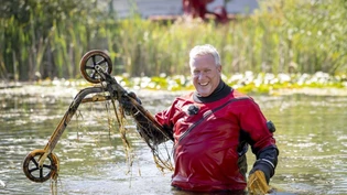 Ein Taucher fischt ein Kickboard anlässlich des nationalen Clean-Up-Days aus einem Teich.