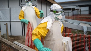 ARCHIV - Helfer kommen in Schutzanzügen zu ihrer Schicht in einem Behandlungszentrum mit Ebola-Erkrankten. Foto: Jerome Delay/AP/dpa