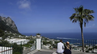 ARCHIV - Touristen blicken auf die Häuser von Capri. Foto: Gregorio Borgia/AP/dpa