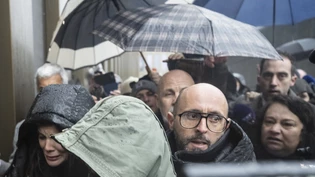 Jessica Moretti (vorne links), begleitet von ihrem Ehemann Jacques Moretti, wurde bei ihrer Ankunft auf dem Fachhochschul-Campus Energypolis in Sitten am Donnerstagmorgen ausgepfiffen.