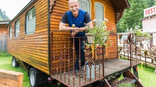 Ein Stück jenische Geschichte: Daniel Huber, Präsident der Radgenossenschaft der Landstrasse, steht auf dem Campingplatz Rania in Zillis vor dem historischen jenischen Wohnwagen (2017). 