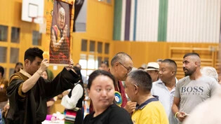 Während der Eröffnungszeremonie wird das Bild des Dalai Lama, dem spirituellen Oberhaupt des tibetischen Volkes, auf die Bühne getragen.