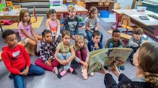 Glarner Kinder lernen mit dem Vorlesen: Die Lehrerin einer 1. Klasse liest ein Buch vor und spricht mit den Kindern darüber. 


