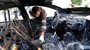Komplett ausgebrannt: Mitglieder des Zivilschutzes inspizieren am Tag nach dem Drohnenangriff auf einen Vorort der libanesischen Grossstadt Beirut von Dienstagabend ein Fahrzeug. 