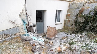 Gewaltige Brocken: Die Kantonspolizei sondiert die Lage in Felsberg, ein Felsbrocken bleibt auf einem Feld liegen, einer der Felssplitter wird erst von einer Hausfassade gestoppt.
