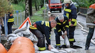 Arbeitsintensiv: Bei einem Hochwasser am 5./6. August 2010 in Glarus Nord verlegen Feuerwehrleute Beaver-Hochwassersperren und Sandsäcke. 