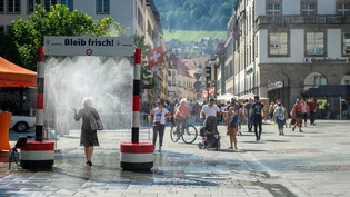 Ein Tropfen auf den heissen Stein: An einem der immer zahlreicheren Hitzetage – hier im vergangenen September – finden Passanten am Churer Postplatz eine kurze Erfrischung. 