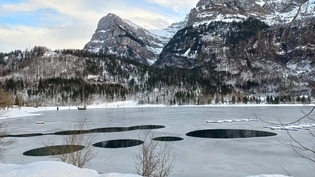 Es ist kein Morsecode: Eine Eisdecke bedeckt derzeit den Klöntalersee, aber beim Bootssteg weist die Eisschicht Löcher auf.