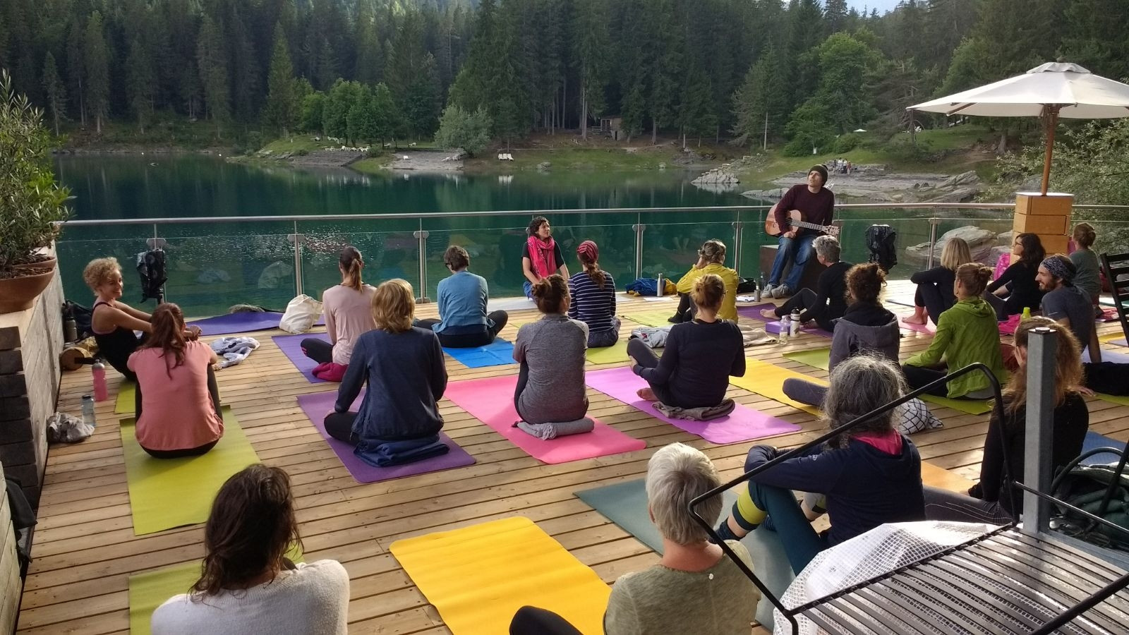Yoga und Livemusik am Caumasee: Festivalorganisatorin Katharina Bogner (mit pinkfarbenem Schal) unterrichtet, Pascal Gamboni macht Musik.