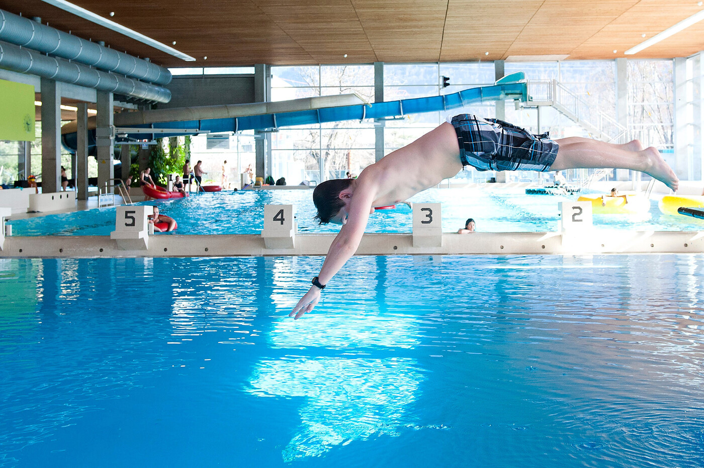 Spielnachmittag: Ein Junge springt ins Wasser, während sich im Hintergrund andere mit den Spielgeräten beschäftigen.